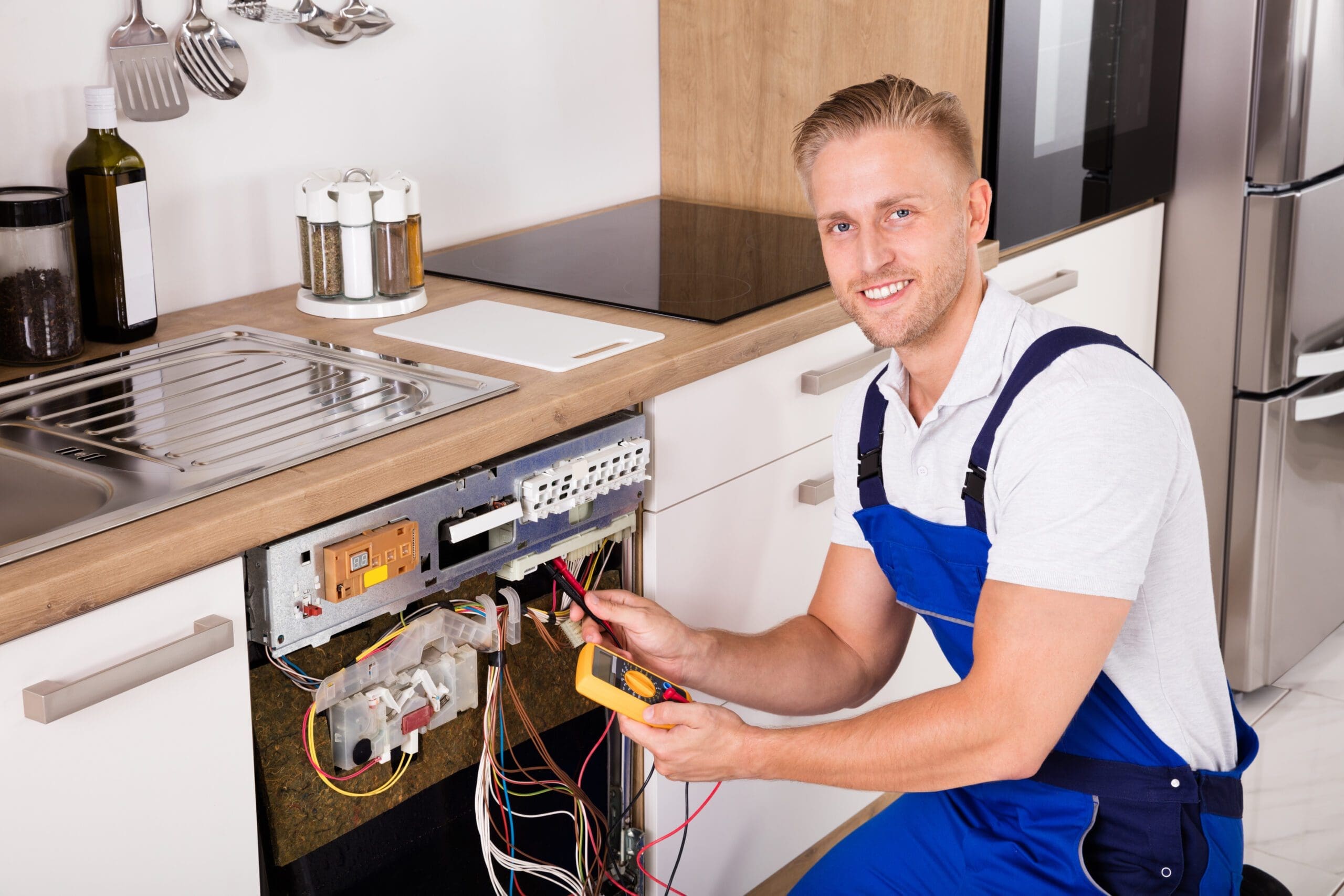 Male Technician Checking Dishwasher With Digital Multimeter